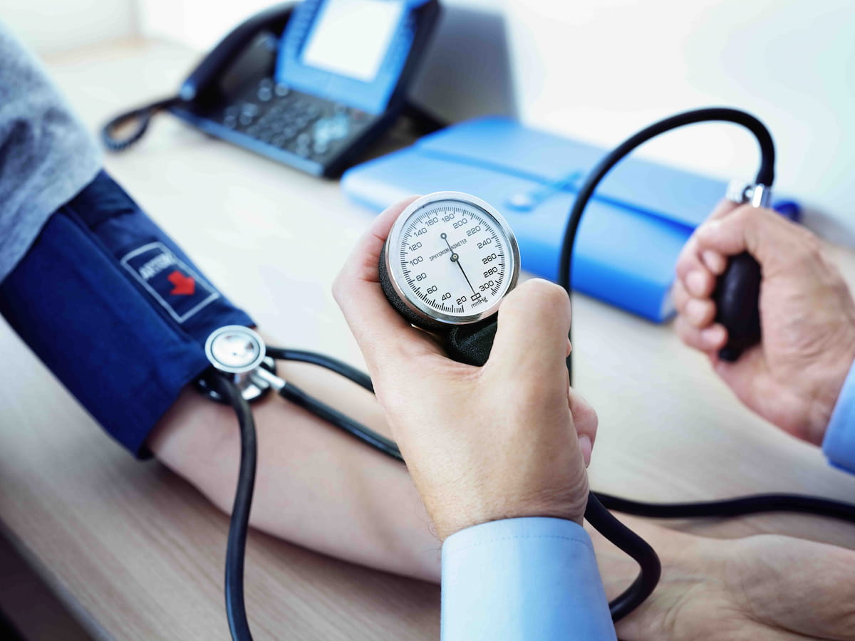A healthcare professional measuring a patient's blood pressure using a sphygmomanometer.