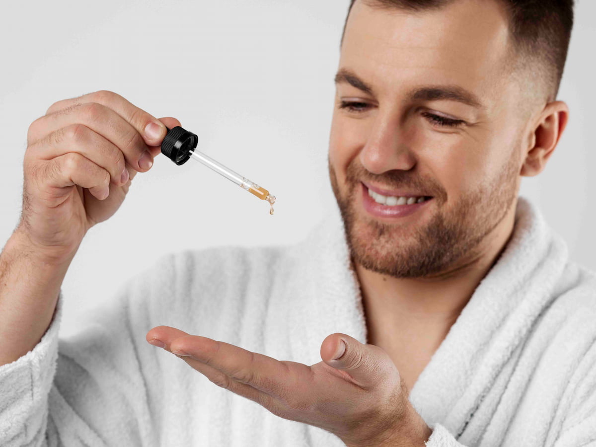 A man is holding an oil bottle and thinking how to apply oil after hair transplant