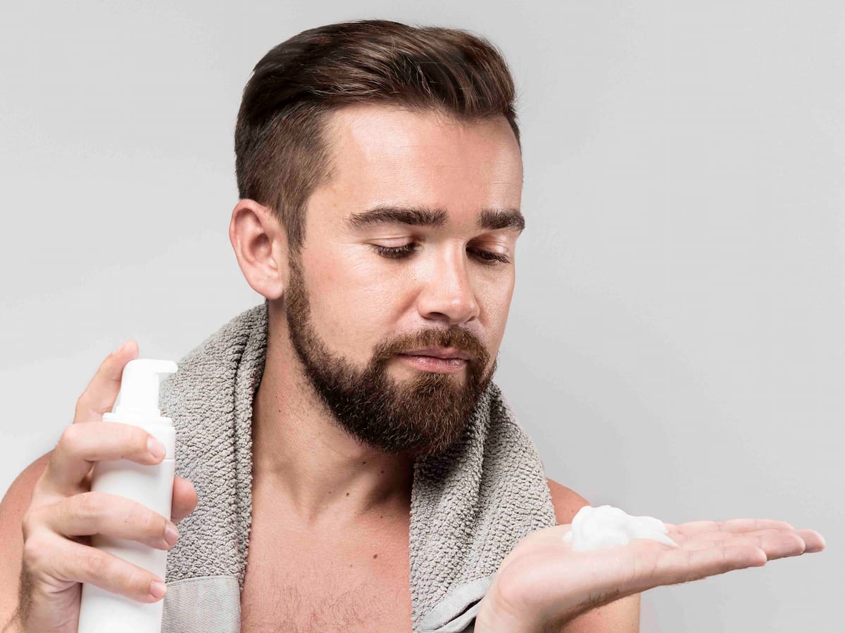 Man applying hair care product after transplant, representing when to use conditioner after hair transplant.